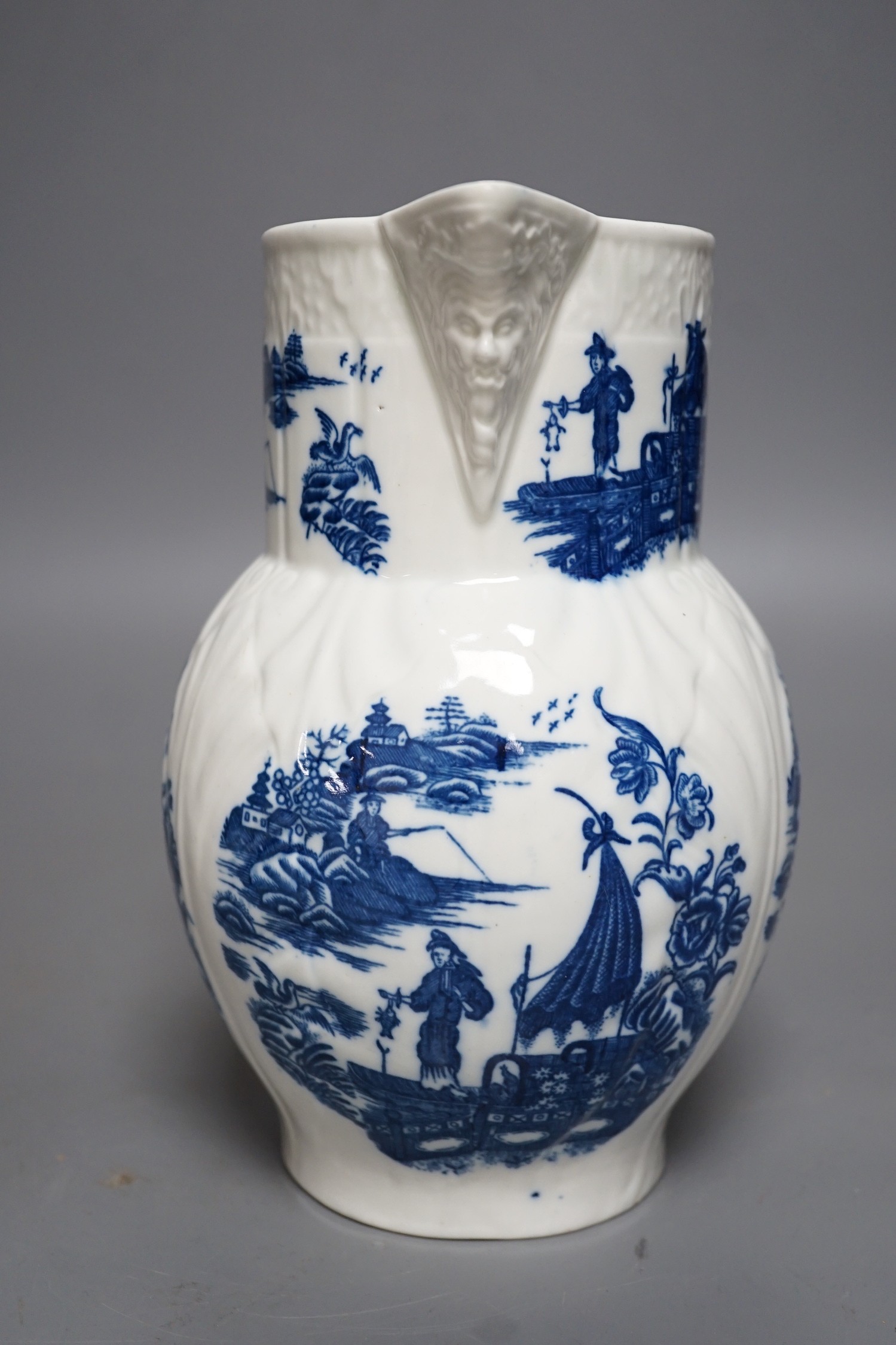 A Caughley baluster mask jug of cabbage leaf moulded shape, printed in underglaze blue with five landscapes of the Fisherman, Sx mark, 19cms high